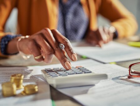 An image of a woman pressing a calculator and carrying out credit checks for renters.